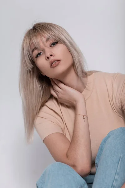Piękna Młoda Blondynka Modnej Beżowej Koszulce Stylową Fryzurą Siedzi Pobliżu — Zdjęcie stockowe