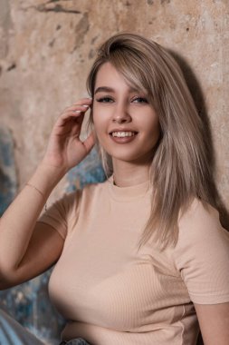 Hoş, mutlu bir genç kadının portresi. Muhteşem bir gülümsemesi var. Odadaki eski bir tuğla duvarın yanında sarı saçlı, şık elbiseli. Odada dinlenen oldukça neşeli bir model kız. Komik bayan..