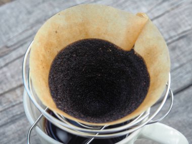 Kahve damlıyor ve ahşap sehpada buzlu kahve var. 