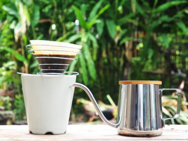 Kahve damlıyor ve ahşap sehpada buzlu kahve var. 