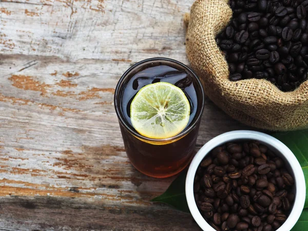 Kahve damlıyor ve ahşap sehpada buzlu kahve var. 