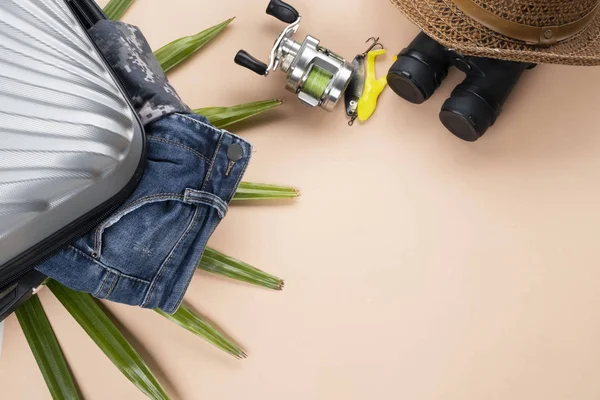 Platte lay grijs koffer met jeans, spinnen van visgerei, bi — Stockfoto