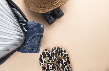 Dürbün, şapka, kot pantolon ve kum o ile Düz yatıyordu gri bavul