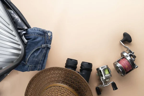 Maleta plana gris con prismáticos, sombrero, jeans, spinning para — Foto de Stock