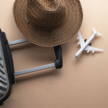 Kahverengi şapka ve hamur üzerinde mini uçak ile düz yatıyordu gri bavul