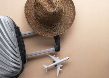 Kahverengi şapka ve hamur üzerinde mini uçak ile düz yatıyordu gri bavul