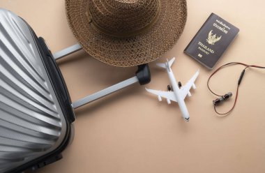 Düz kahverengi şapka, Mini uçak, Tayland P ile gri bavul yatıyordu