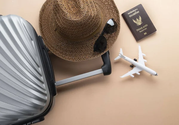 Flat lay grey suitcase with brown hat, mini airplane,Thailand Pa