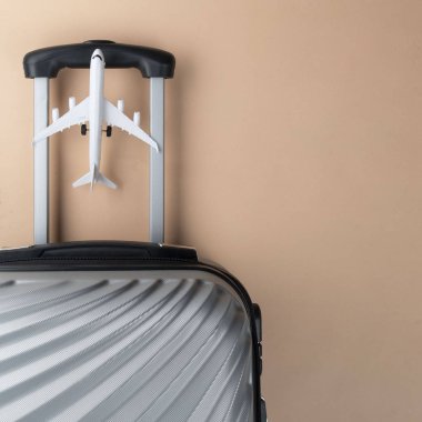 Pastel arka planda mini uçak ile düz yatıyordu gri bavul. 