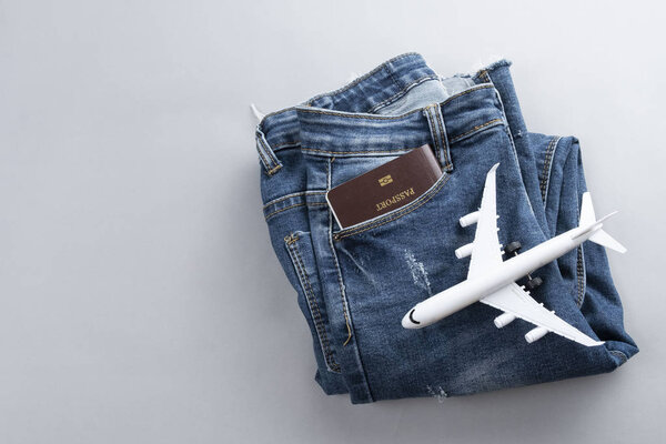 Flat lay mini airplane and traveler accessories on grey backgrou