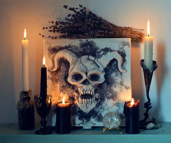 Scary box with devil fave, burning black and white candles and lavender flowers. Magic gothic ritual. Wicca, esoteric, divination and occult background with vintage objects