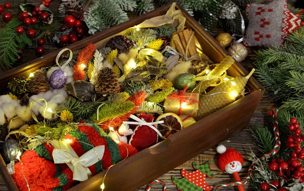 Wooden box with gifts, socks, conifer, decorations, twig on table, vintage concept.