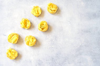 Gri beton bir yüzey üzerinde makarna fettuccine pişirirken..