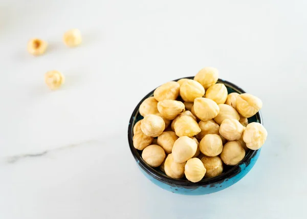 Hazelnuts Blue Bowl Stands White Plate Delicious Peeled Hazelnuts Healthy — Stock Photo, Image