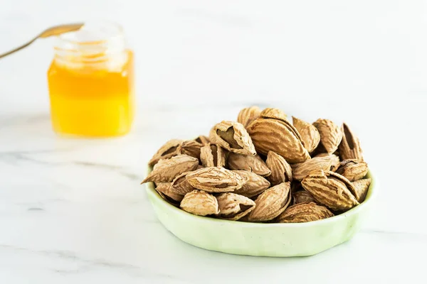 Salted Almonds Shells Light Green Bowl Stands White Background Background — Stock Photo, Image