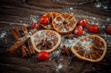 Kurumuş portakal dilimleriyle işkembe ağacının kırmızı meyveleri.