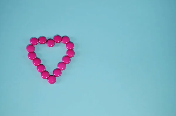 heart of pink buttons on a mint background with copy space horizontal orientation