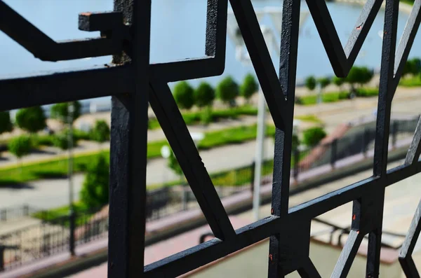 pattern of an iron forged fence against the backdrop of the city\'s waterfront horizontal orientation