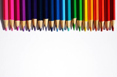 Renkli kalemlerden oluşan bir gökkuşağı yukarıdaki yatay yönelimden bir metin görüntüsü için çerçeve olarak en üst köşeye dizilmiştir