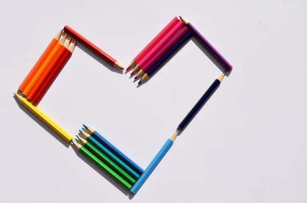 heart of colored pencils on a white background with copy space horizontal orientation