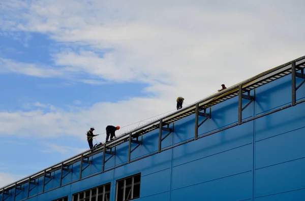 workers on the roof of the building with insurance perform work on the construction of the building men