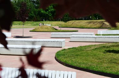 Bulvardaki beyaz ahşap banklar. Kırmızı akçaağaç yapraklarıyla çerçevelenmiş. Şehirde bir yürüyüş.