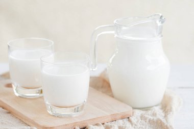 Süt şişesi ve süt bardağı ahşap masada. Bardak sürahi ve bardakta süt. Sağlıklı beslenme kavramı.