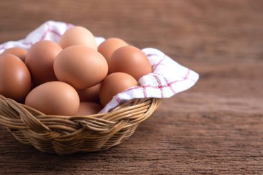 Hasır sepetlerdeki yumurtalar ahşap zemin, kahvaltı ve sağlık kavramları