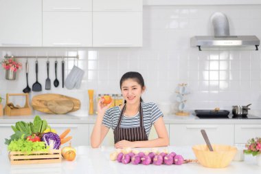 Mutfakta yemek yapan kadın, sebzelerle yemek yapan Asyalı kadın, temiz beyaz mutfak..