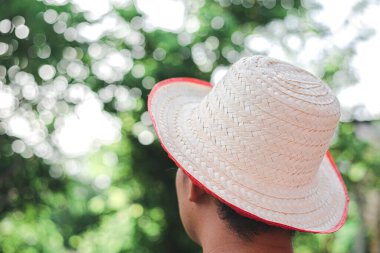 Hasır şapkalı genç adam, yaz ve tatil konsepti olan bir plaj yürüyüşü için hasır şapka giydi..