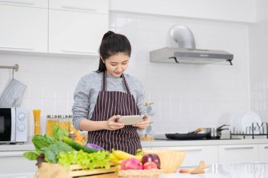 Modern bir mutfakta salatayla selfie, modern mutfakta yemek yaparken selfie çeken güzel bir kadın. Sağlıklı yiyecekler ve oruç kavramları