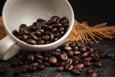 Kahve fincanı ve arka planda kavrulmuş fasulye..