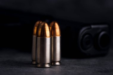 Mermi 9mm. Karanlık taş masada. Mermiler ve askeri teknoloji..