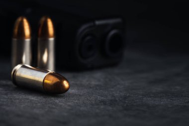 Mermi 9mm. Karanlık taş masada. Mermiler ve askeri teknoloji..