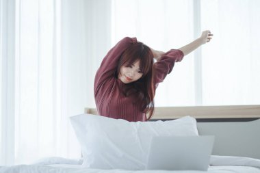 Yatağında uyanan güzel bir kadın uyandıktan sonra yatakta uzanan bir kadın.