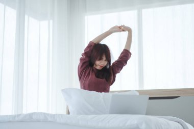 Yatağında uyanan güzel bir kadın uyandıktan sonra yatakta uzanan bir kadın.