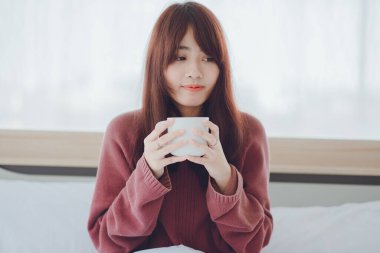 Beyaz bir odada, yatağın üzerinde kahve, çay, süt içen bir kadın (kahve, çay, süt))