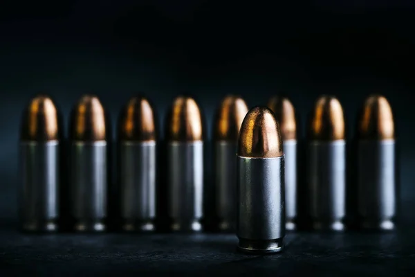 Mermi 9mm. Karanlık taş masada. Mermiler ve askeri teknoloji..