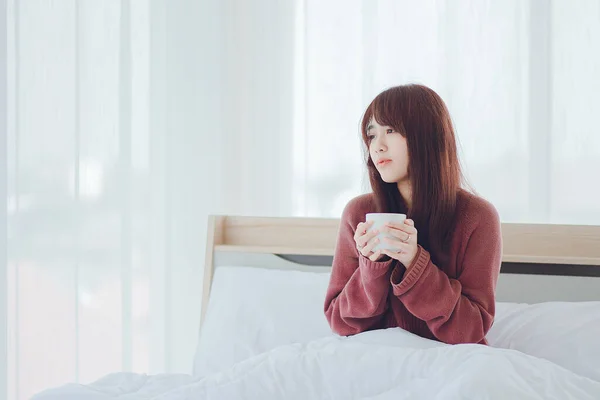 Mujer Sosteniendo Una Taza Café Leche Cama Una Habitación Blanca —  Fotos de Stock