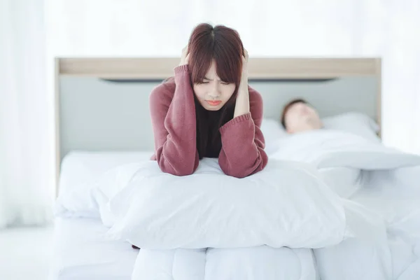 Kadın Uyuyamazken Erkek Yatakta Uyuyor Horluyor Kulaklarını Büyük Yastıklarla Kapatıyor — Stok fotoğraf