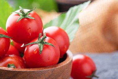 Taze domatesler. Koyu arkaplanda tabakta taze domatesler..