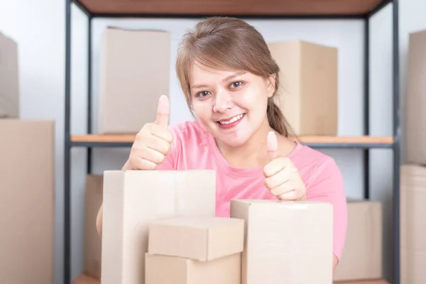 Selling online work from home. Women business owner working at home with packing box on the workplace - online shopping