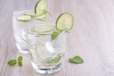Kırsal bir masada mojito kokteyli, taze limonlu mojito kokteyli ve ahşap arka planda nane.