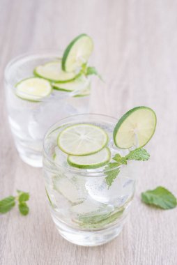 Kırsal bir masada mojito kokteyli, taze limonlu mojito kokteyli ve ahşap arka planda nane.