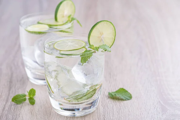 Kırsal bir masada mojito kokteyli, taze limonlu mojito kokteyli ve ahşap arka planda nane.