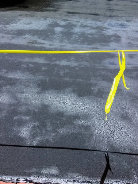 用黄色塑料胶带把一段新的泥浆封路封锁起来 以便固定和擦干 — 图库照片