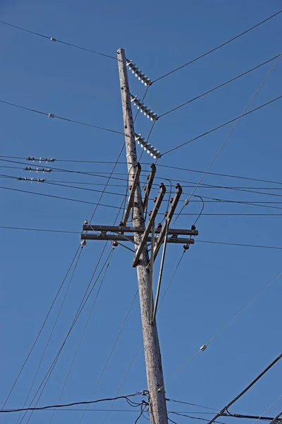 深蓝色天空下的配电塔和电线的低角度视图 — 图库照片