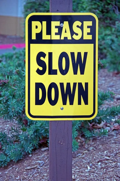 Widok Bliska Znak Please Slow Zakręcie Alejki Parkingowej — Zdjęcie stockowe
