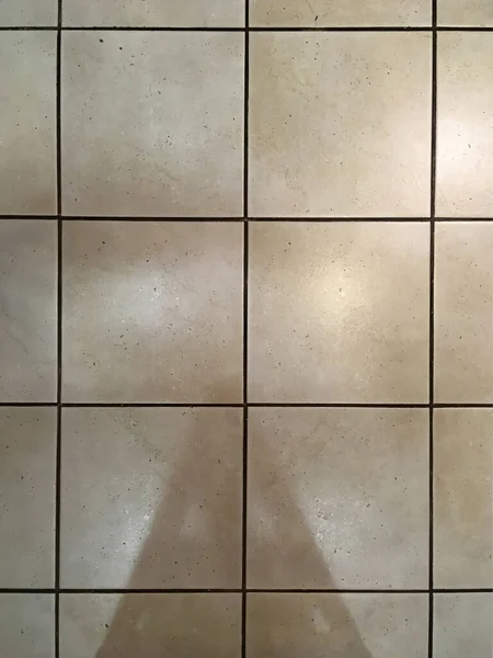 光の反射と影を示すタイル張りのキッチンフロアの高い角度ビュー — ストック写真