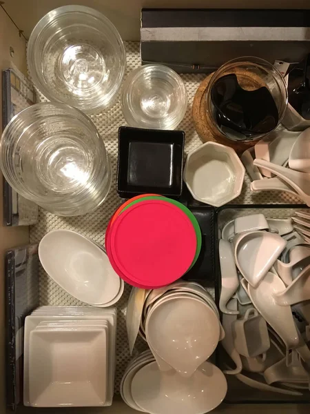 厨房抽屉里摆满了小件陶器 咖啡杯 玻璃碗等的高角度图像 — 图库照片